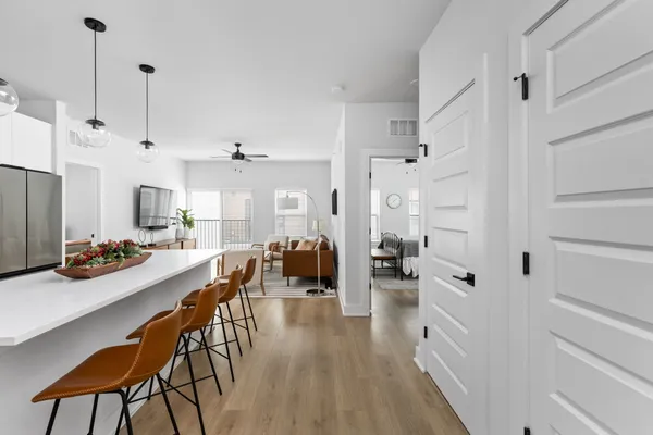 a view of a dining room and livingroom with furniture wooden floor a chandelier