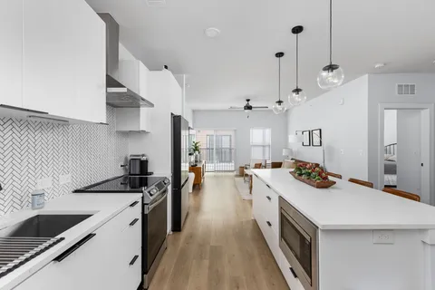 a kitchen that has a sink a stove and a wooden floor