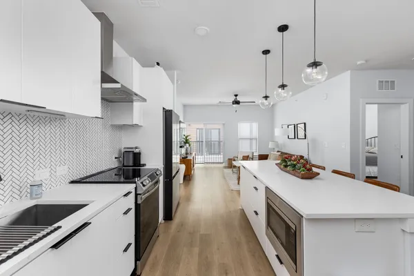 a kitchen that has a sink a stove and a wooden floor