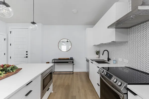 a kitchen with a sink a stove and cabinets
