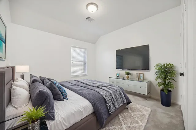 a bedroom with a bed and a flat screen tv