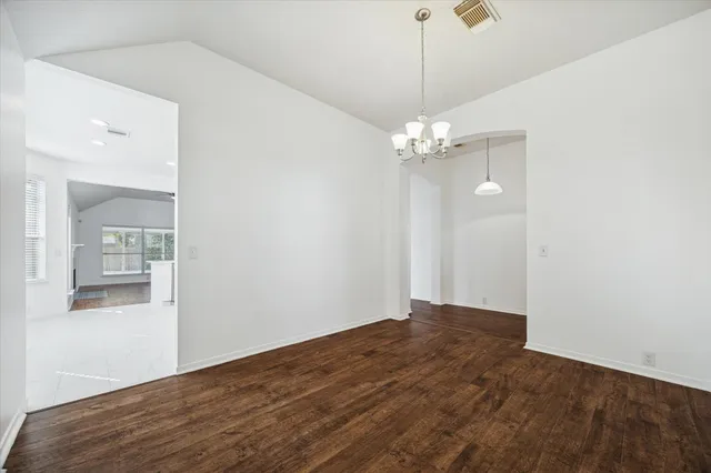 a view of a chandelier in big room with wooden floor