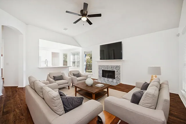 a living room with furniture a fireplace and a flat screen tv