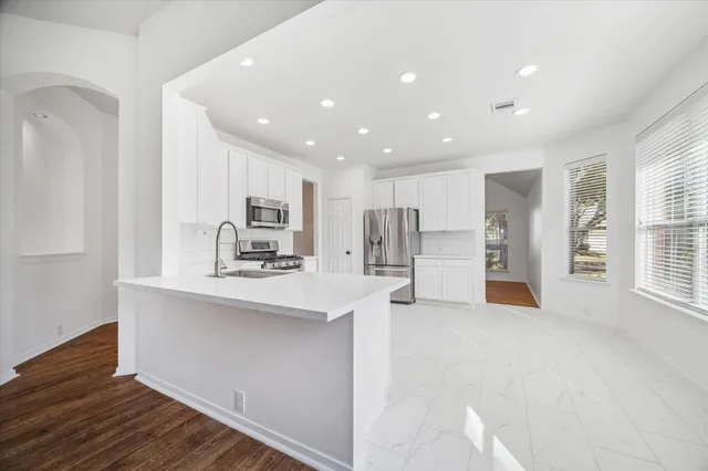 a view of kitchen with stainless steel appliances refrigerator oven and cabinets