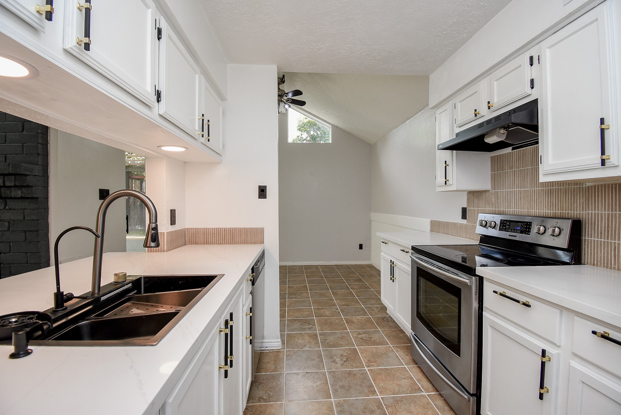 8715 Vinkins Road Houston, TX 77071 - Photo 15 of 48 Prepare your favorite meals in this bright, updated kitchen featuring quartz countertops, modern fixtures, abundant cabinetry, stainless steel appliances, and an open layout that keeps you connected to family and guests