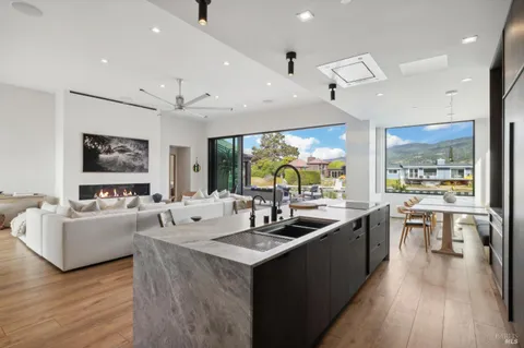 a kitchen with counter top space a sink appliances and a large window