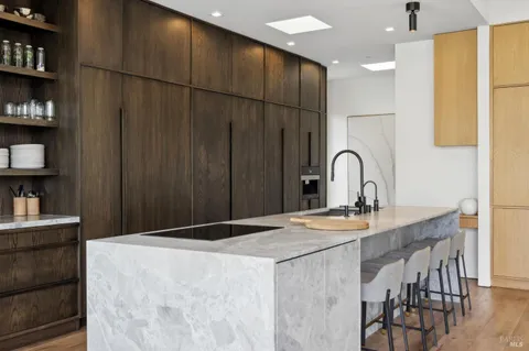 a kitchen with kitchen island a sink a counter and a refrigerator