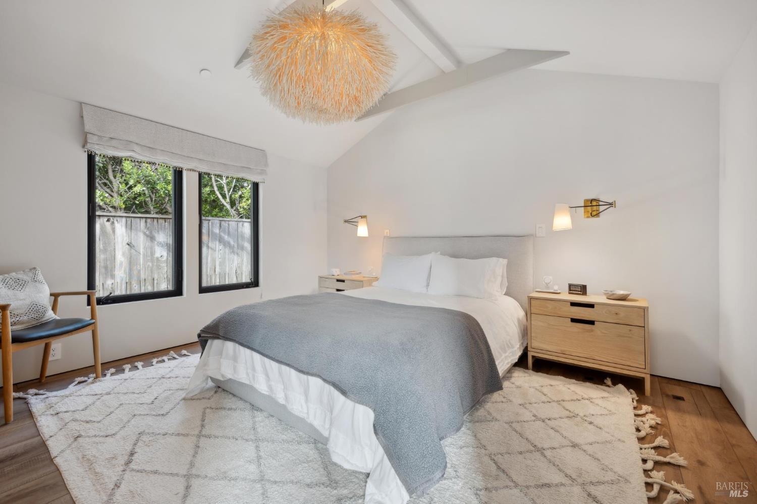 297 Seadrift Road Stinson Beach, CA 94970 - Photo 19 of 44 a bedroom with a bed and a chandelier