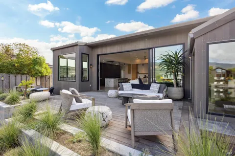 a living room with patio furniture and a wooden floor