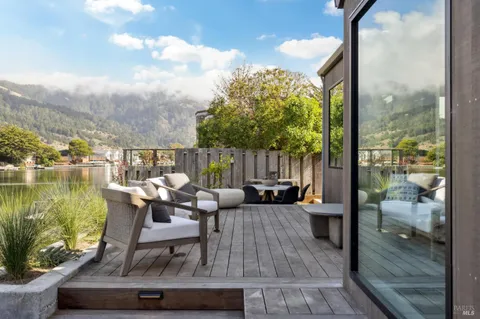 a view of a patio with a dining table and chairs with wooden floor