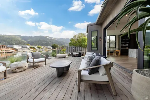 a view of a roof deck with table and chairs couches with wooden floor