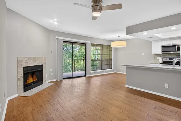 a view of empty room with wooden floor and fireplace