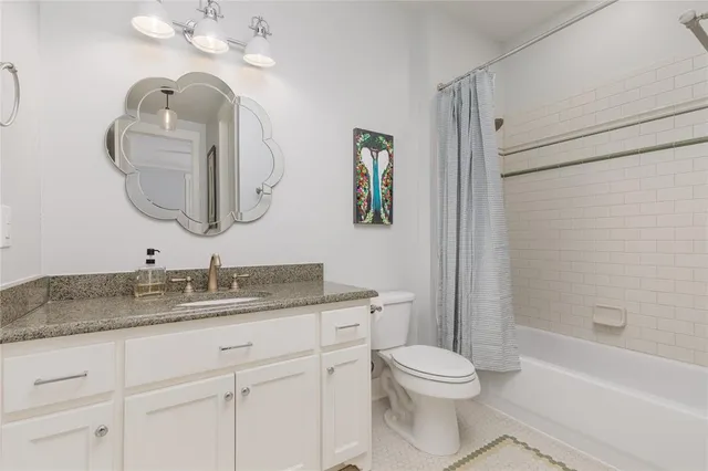 a bathroom with a toilet a sink a tub and mirror