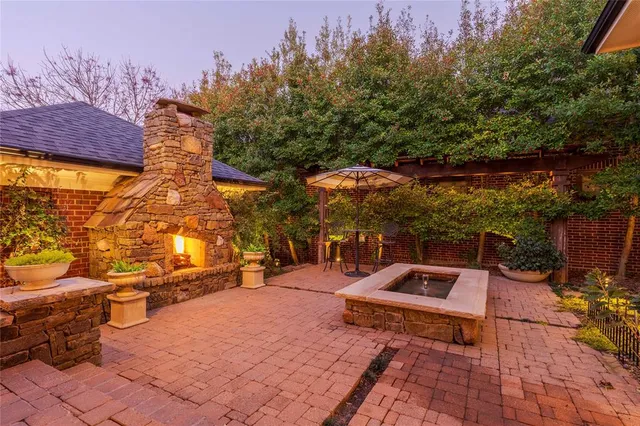 a roof deck with table and chairs and potted plants