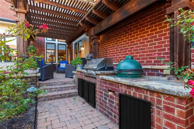 a kitchen with stainless steel appliances granite countertop a barbecue grill and couches chair