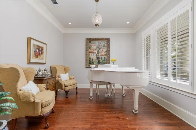 a living room with furniture two window and a wooden floor