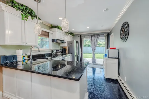 a kitchen with stainless steel appliances granite countertop a sink a stove and a refrigerator