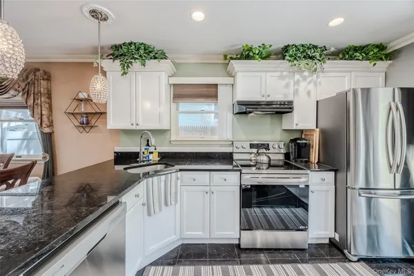 a kitchen with kitchen island granite countertop a stove sink and refrigerator