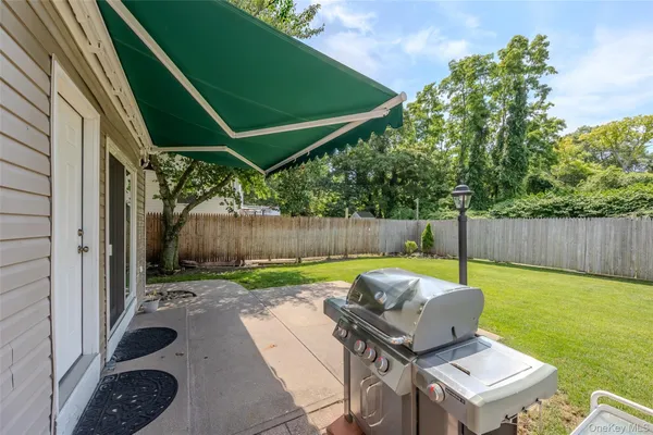 a backyard of a house with barbeque oven table and chairs
