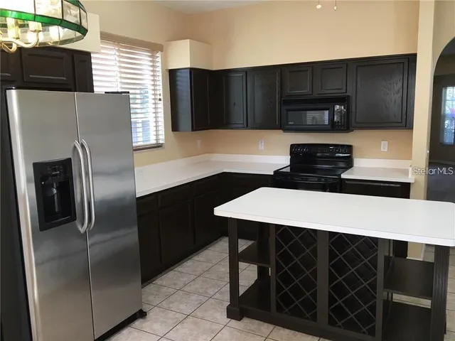 a kitchen with a sink a refrigerator and cabinets
