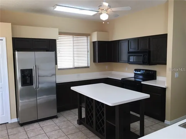 a kitchen with stainless steel appliances a table chairs and a refrigerator