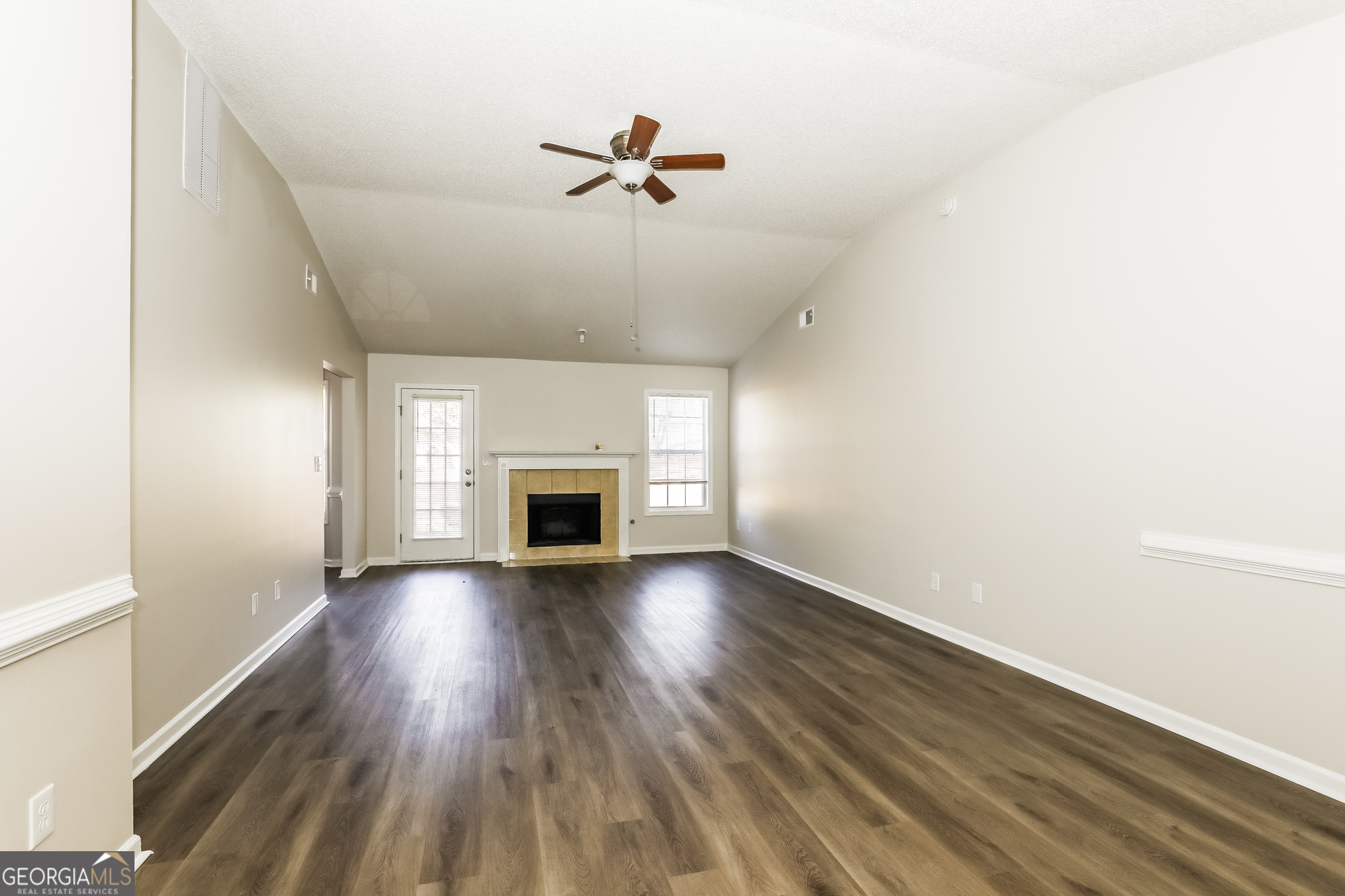 1915 Portwest Way Hampton, GA 30228 - Photo 2 of 16 an empty room with wooden floor fireplace and windows