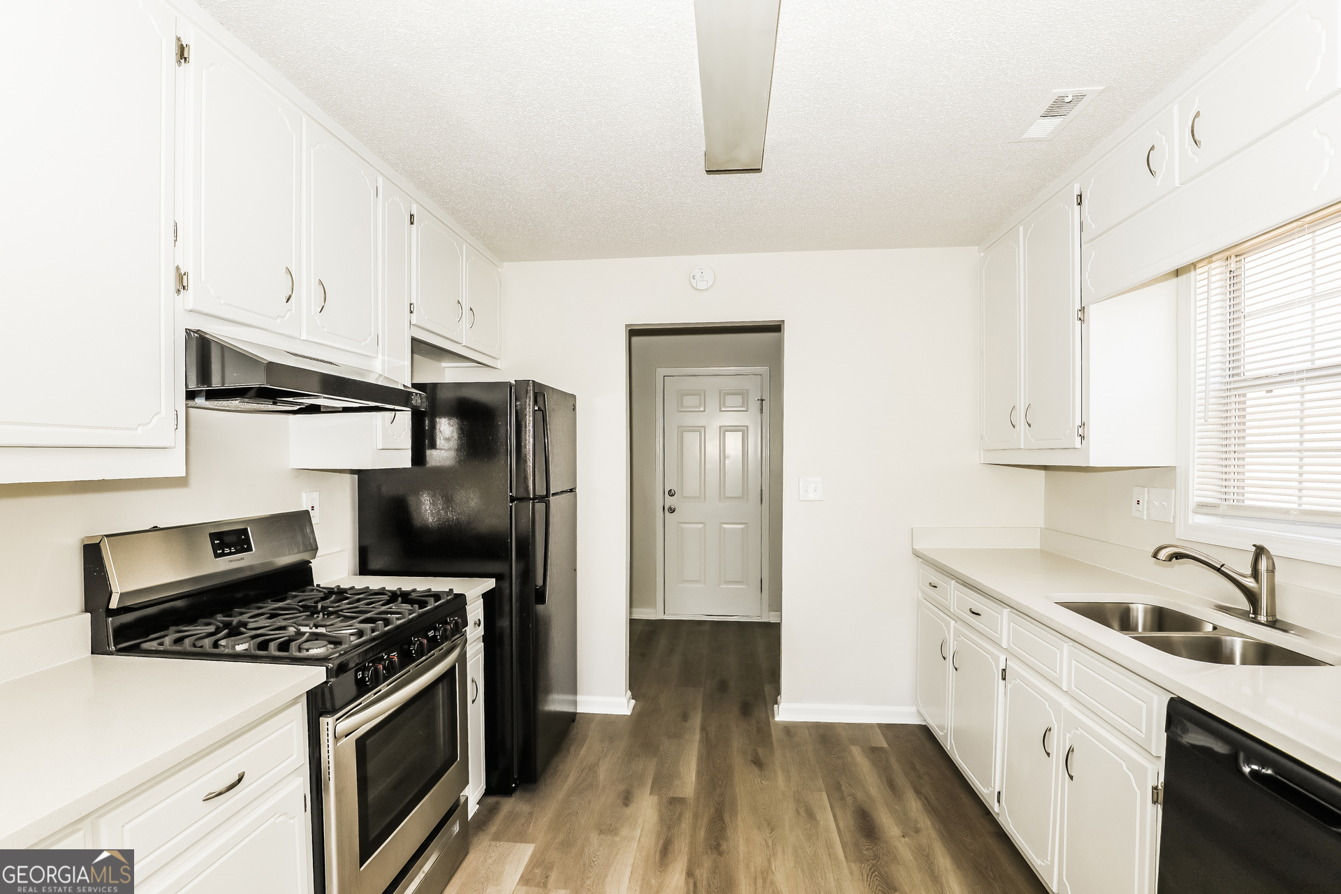 1915 Portwest Way Hampton, GA 30228 - Photo 5 of 16 a kitchen with stainless steel appliances a sink a stove and a refrigerator
