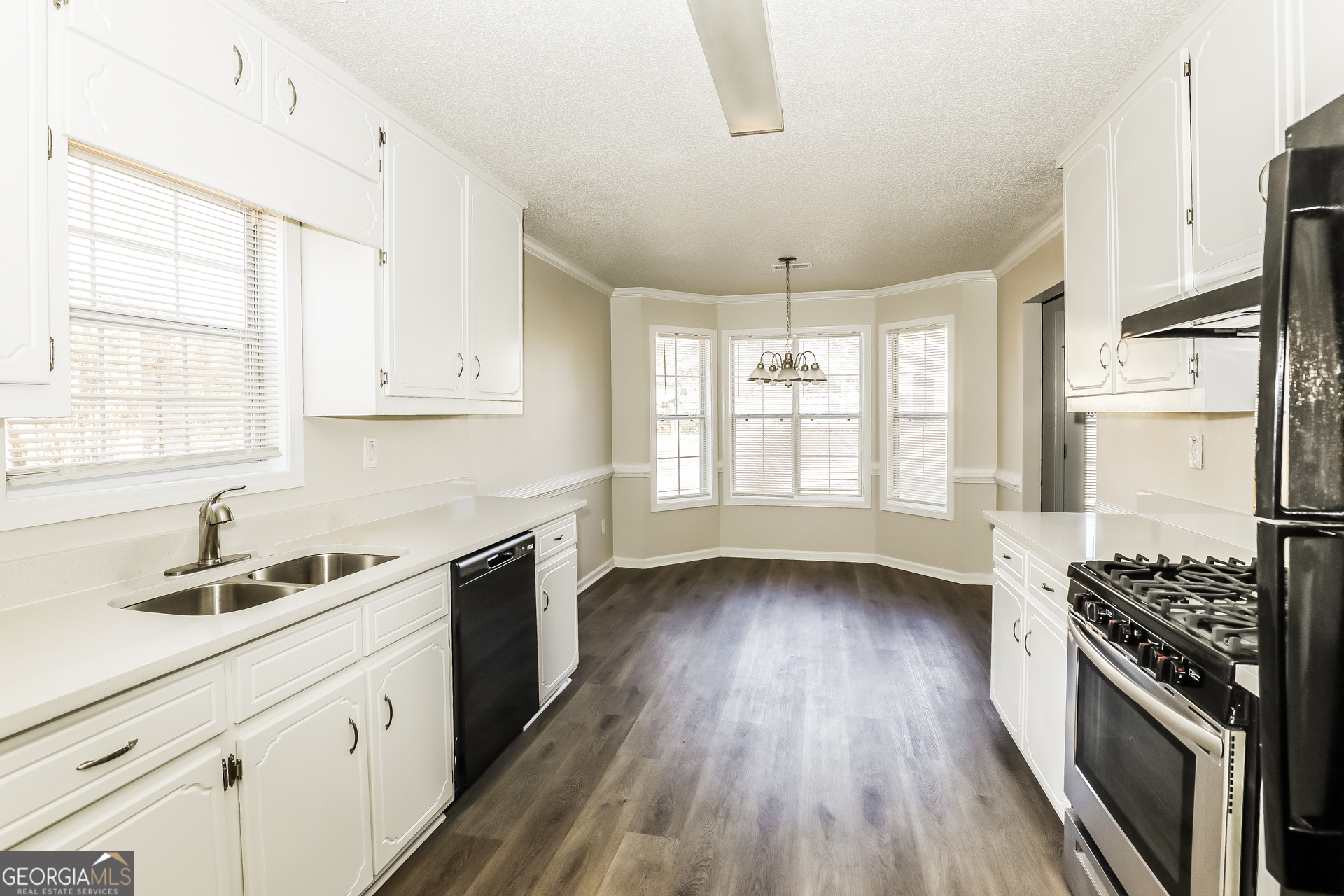 1915 Portwest Way Hampton, GA 30228 - Photo 6 of 16 a kitchen with a sink wooden floor and stainless steel appliances