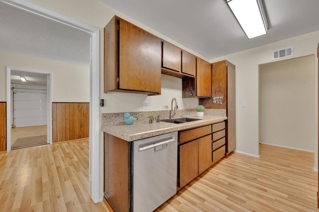 9430 Lake Canyon Road Santee, CA 92071 - Photo 14 of 52 a kitchen with stainless steel appliances granite countertop a sink stove and wooden floor