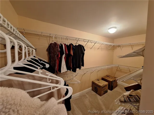 a view of walk in closet with clothes and shoes