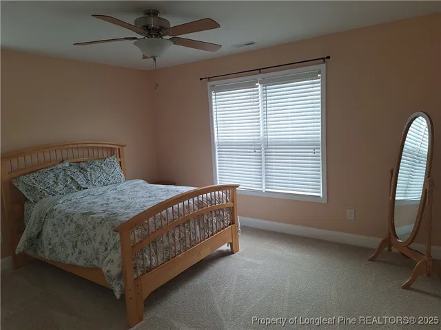 a bedroom with a bed and a flat tv screen on a dresser