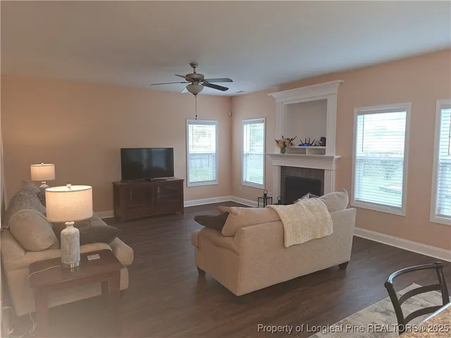 a living room with furniture a flat screen tv and a fireplace