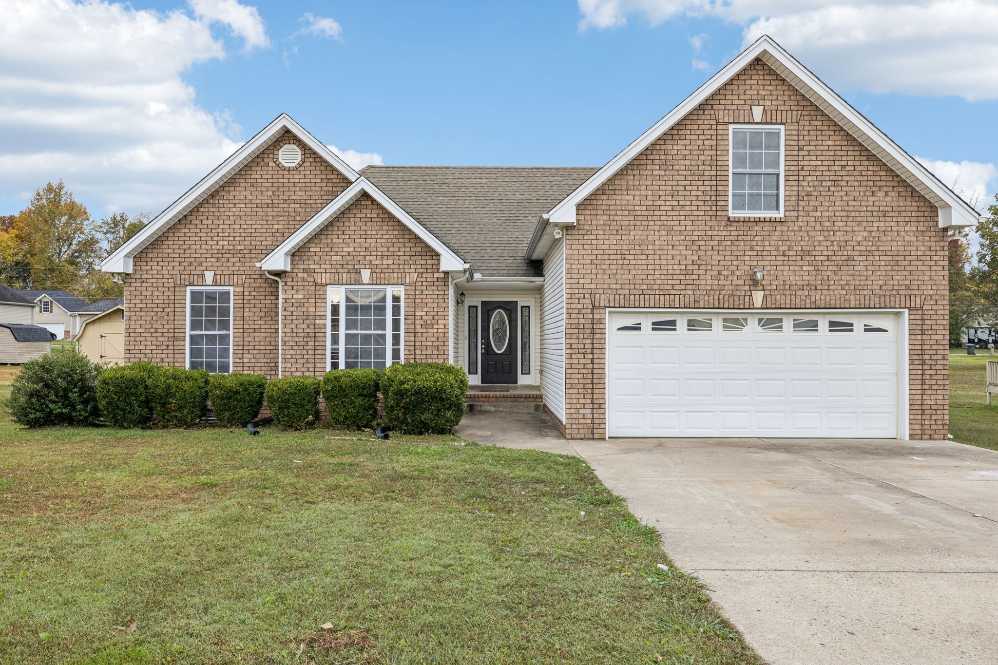 a front view of a house with a yard and garage