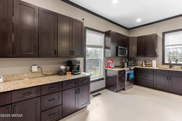 a kitchen with a refrigerator stove top oven sink and cabinets