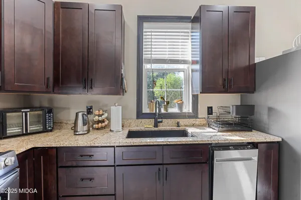 a kitchen with granite countertop wood cabinets and a window