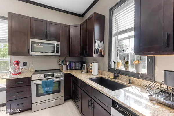 a kitchen with granite countertop cabinets stainless steel appliances and a window