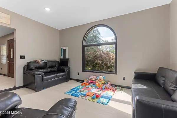 a living room with furniture and a floor to ceiling window