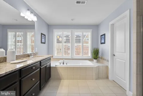 a bathroom with a granite countertop sink a large mirror and a vanity