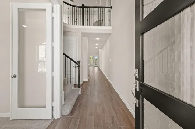 a view of a hallway with wooden floor and staircase