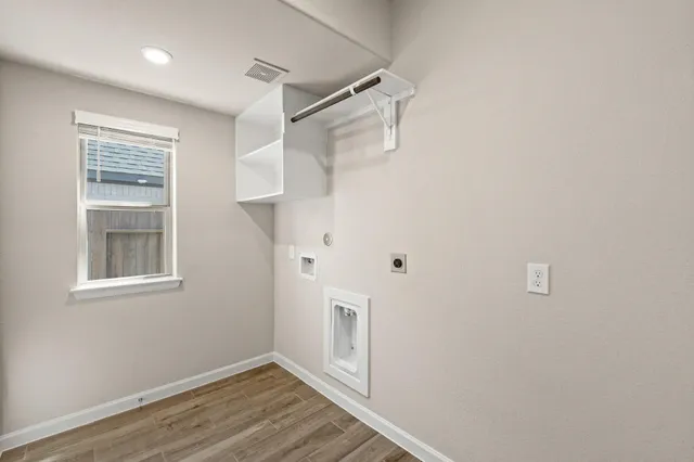 a view of hallway with window and wooden floor