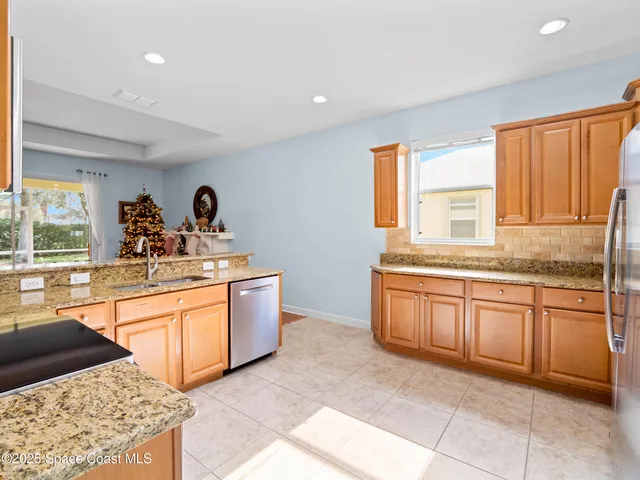 a kitchen with stainless steel appliances granite countertop a refrigerator and a sink