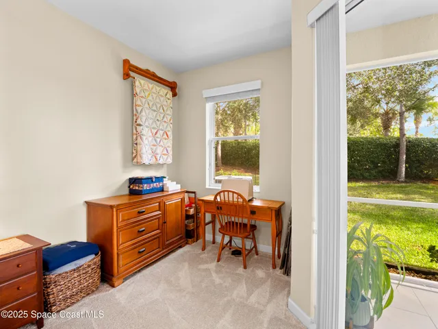 a bedroom with a bed a chandelier and dresser