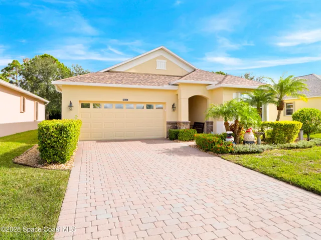 a front view of a house with a garden and plants