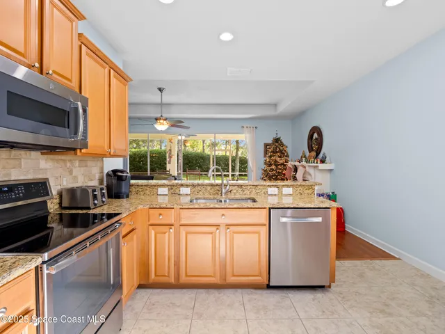 a kitchen with stainless steel appliances granite countertop a stove a sink and a microwave