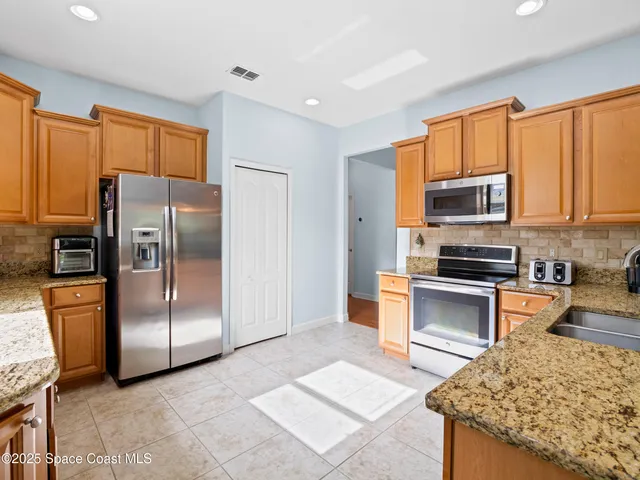 a kitchen with stainless steel appliances granite countertop a sink and cabinets