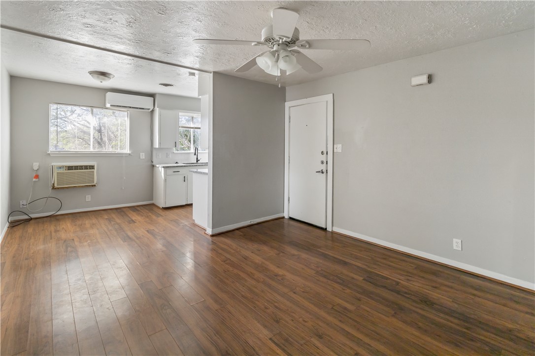 1012-1014 East 23rd Street Bryan, TX 77803 - Photo 12 of 22 an empty room with wooden floor a ceiling fan and windows