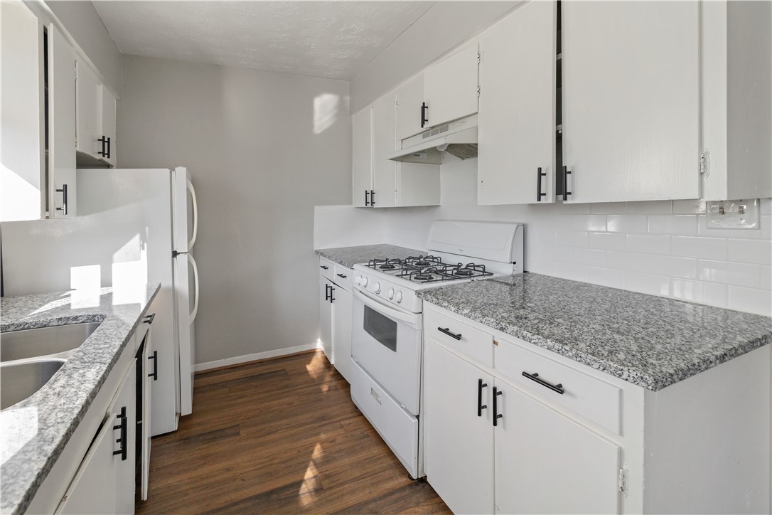 1012-1014 East 23rd Street Bryan, TX 77803 - Photo 9 of 22 a kitchen with stainless steel appliances granite countertop a stove and a sink