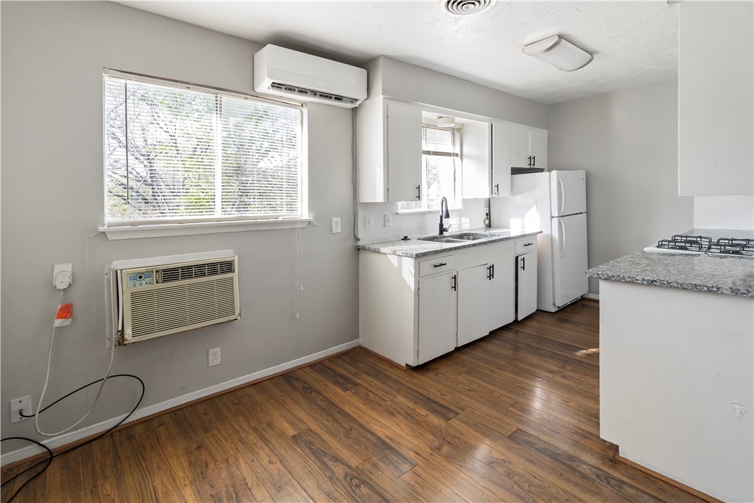 1012-1014 East 23rd Street Bryan, TX 77803 - Photo 10 of 22 a kitchen with sink cabinets and wooden floor