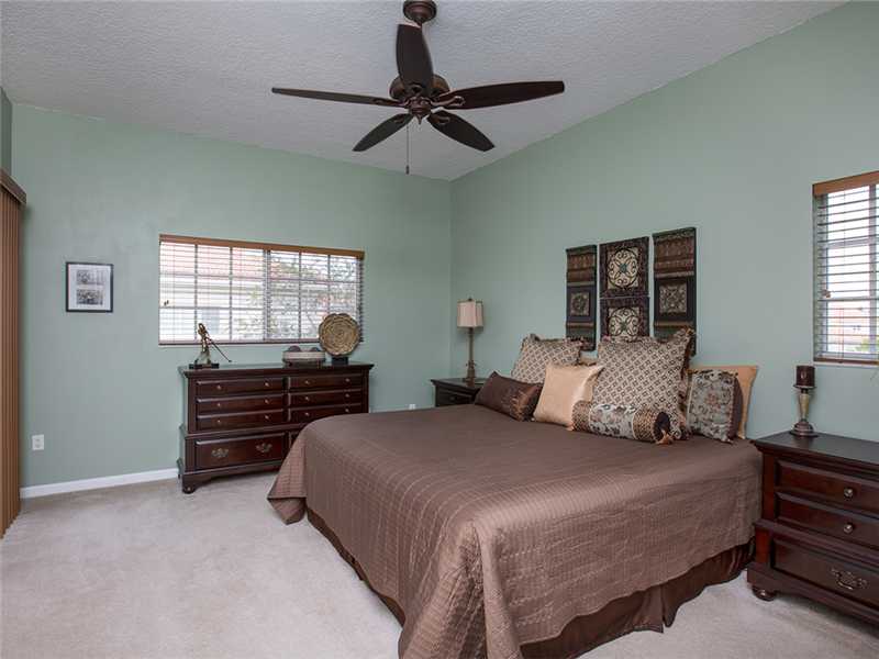 576 7th Square Southwest, Unit 202 Vero Beach, FL 32962 - Photo 16 of 28 a bedroom with a bed and a chandelier