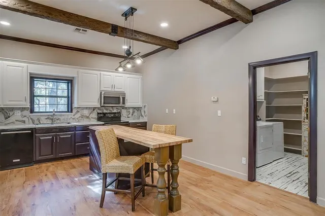 a kitchen with a table chairs refrigerator and cabinets